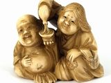 two figurines of a boy and a girl sitting on the ground