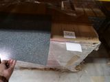 une personne tenant une paire de ciseaux devant une pile de cartons