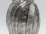 a silver vase that is sitting on a table