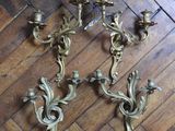 three antique brass wall sconces on a parquet floor