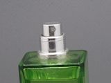 une image représentant un flacon de parfum vert posé sur une table