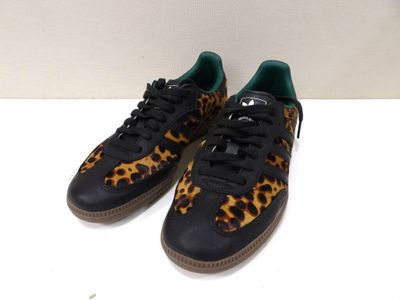 une paire de baskets noires et marron ornées d'un imprimé léopard