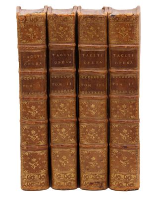 four old books sitting on top of each other on a white surface