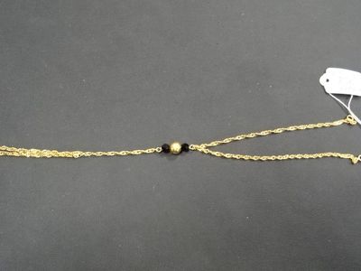 un bracelet en chaîne d'or orné d'une breloque en forme d'oiseau