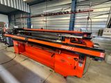 an orange machine is sitting in a warehouse with other machines
