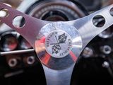 a close up of a steering wheel with a clock on it