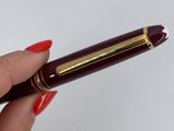 a person holding a pen in their hand on a white surface