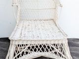 a white wicker chair sitting on a cement floor