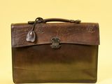 une mallette en cuir marron portant une inscription sur fond jaune