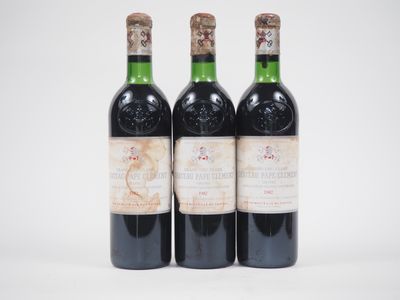 trois bouteilles de vin posées les unes à côté des autres sur une surface blanche