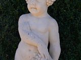 a statue of a boy holding a bunch of grapes