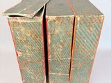 three books are stacked on top of each other on a white surface