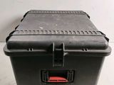 a black box with a red handle on the floor