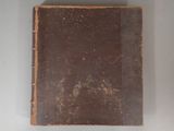 an old book sitting on a table with a white background