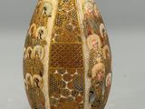a vase that has a gold and white design on it
