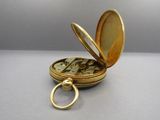 a small gold pocket watch with a keychain on it