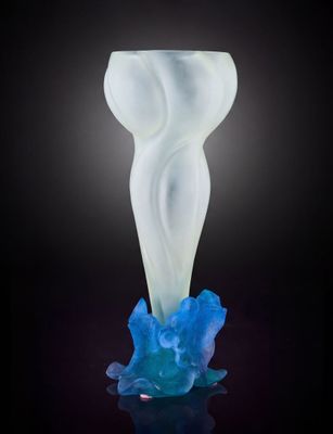 un vase blanc et bleu posé sur une surface noire