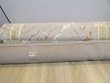 un rouleau de tissu posé sur un parquet
