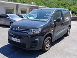 une camionnette Citroën garée sur un parking devant un immeuble