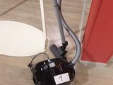 a black and white vacuum on the floor next to a red door