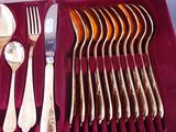 a set of silverware in a velvet case with a spoon, fork, and spoon rest