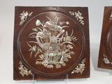 two wooden plaques with flowers and birds on them