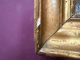 a mirror hanging on a purple wall in a room