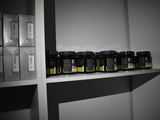 many jars of honeys on a shelf in a room