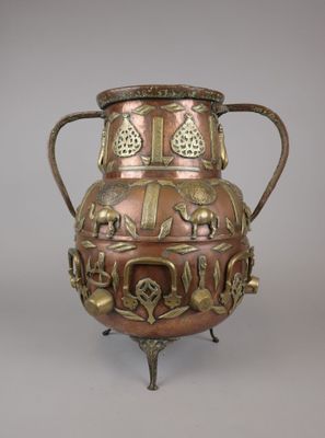 a large metal vase with many designs on it