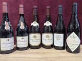 six bouteilles de vin sont alignées sur une table en bois