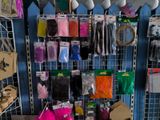 many bags of different colors and sizes of items hanging on the wall