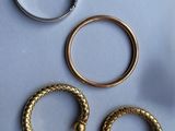 three gold rings and two silver rings on a blue surface