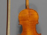 an old violin with a bow and a bow rest on a gray surface