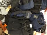 a pile of clothes that is sitting on a bed