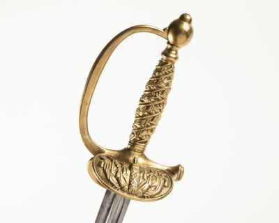 une vieille épée avec un manche en or sur fond blanc