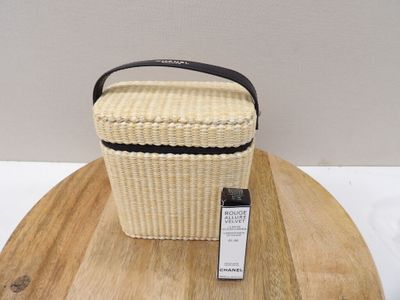 panier en osier beige avec une bordure et une poignée noires, posé sur une table en bois