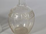a clear glass vase sitting next to a salt shaker