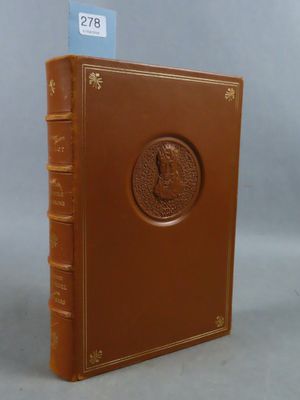 an old book with a brown cover sitting on top of a table