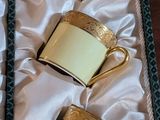 three tea cups in a box with gold trims on a table