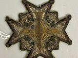 une image représentant une broche en forme d'étoile posée sur une surface blanche