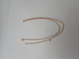 the gold chain is laying on top of a white surface