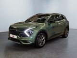 Le SUV vert est garé dans une pièce aux murs blancs.