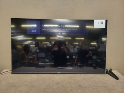 the television is sitting on a table with a remote in front of it
