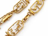 une image représentant un bracelet en or muni d'une chaîne sur laquelle figurent les portraits d'un homme et d'une femme