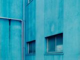 une borne d'incendie située devant un immeuble bleu