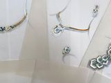several pieces of jewelry displayed on a table with a white background