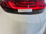 the tail lights of a white car with a sticker on it ' s tail