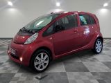 une petite voiture rouge garée sur un sol à damier
