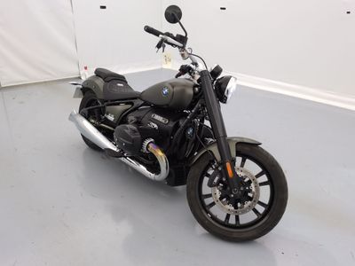 une moto noire garée dans une pièce aux murs blancs