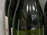 quatre bouteilles de vin sont alignées sur une table